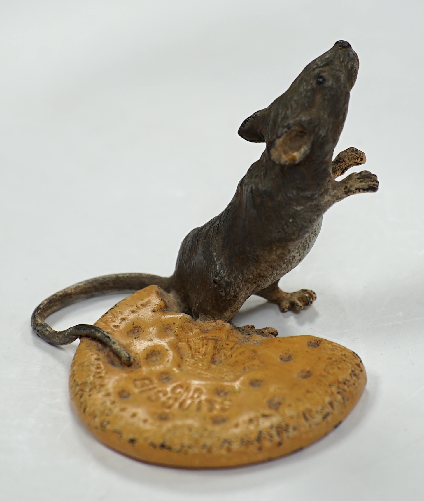 Franz Bergmann (1861-1936), a cold painted bronze study of a mouse and a biscuit, stamped marks to base, 5cm tall. Condition - fair